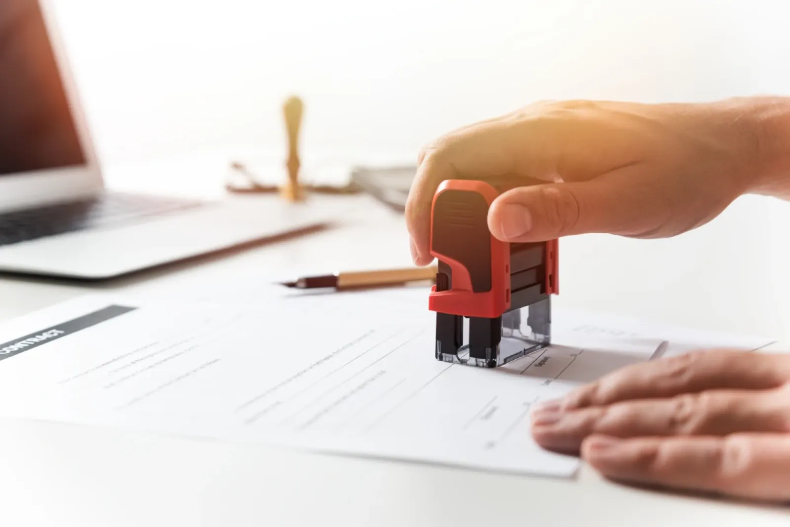Foto zeigt eine Hand, die gerade ein Dokument stempelt